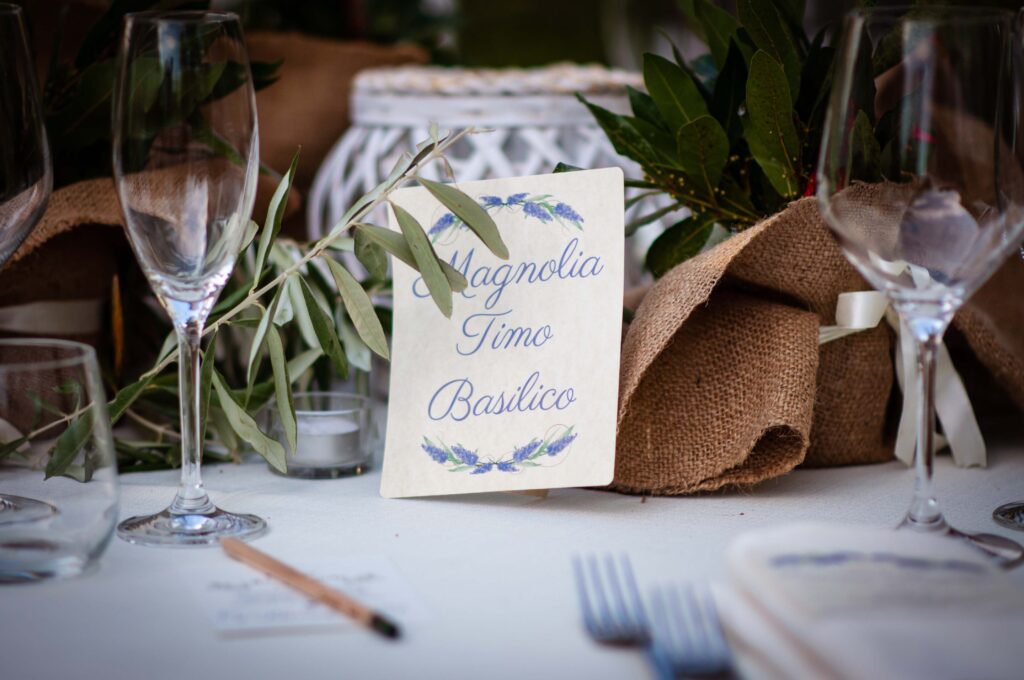 Dettaglio di centrotavola con erbe aromatiche e ulivo, alternativa economica e sostenibile per il budget fiori matrimonio.